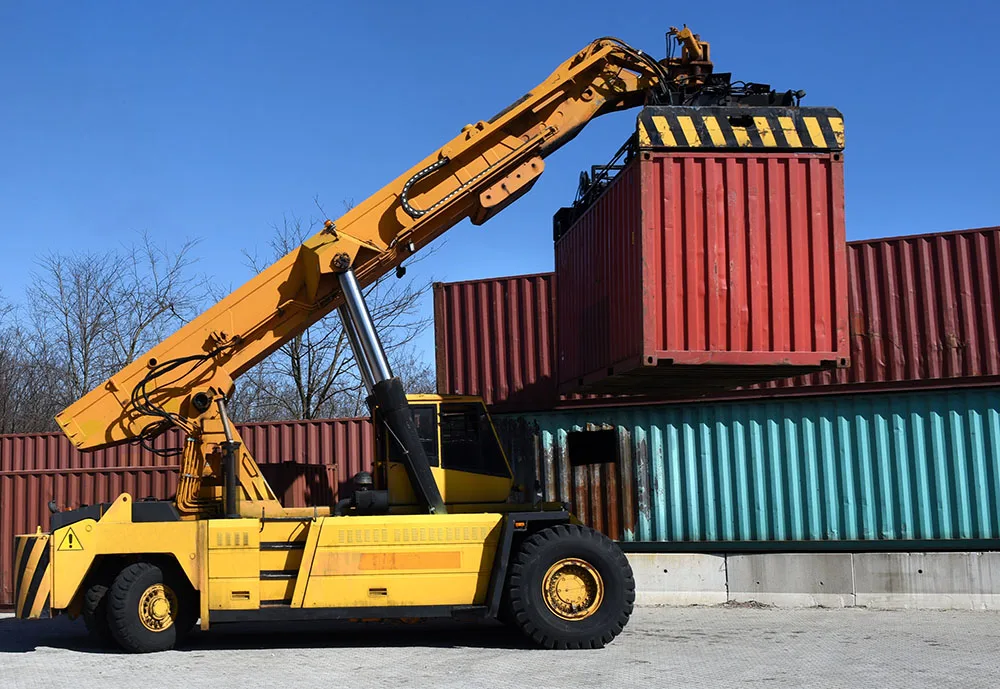 Container handling vehicle moving a shipping container in a port terminal