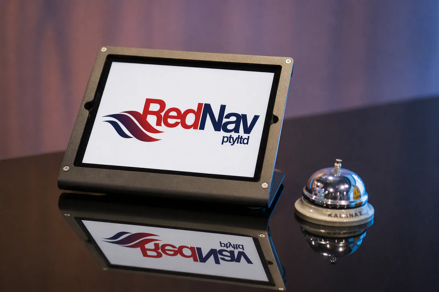 The Red Nav logo on a tablet in a desk stand, beside a reception bell